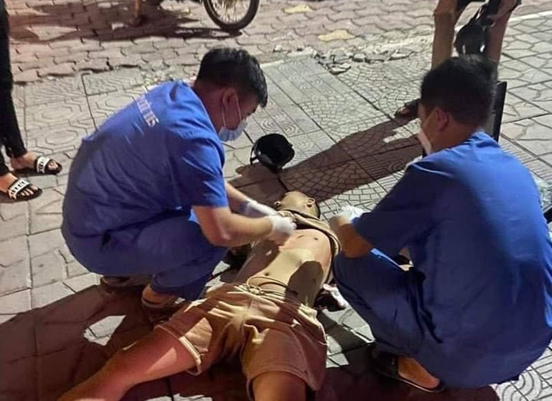Nhân viên y tế đang cấp cứu cho nam thanh niên bị đâm gục trên vỉa hè phố Láng Hạ, Hà Nội